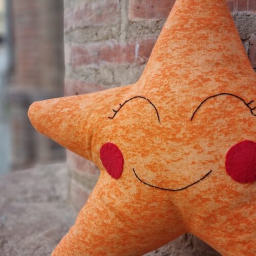 Cojines infantiles con forma de estrella en alegres y brillantes colores. El cojín estrella es el cojín ideal para decorar dormitorios de bebés y niños.