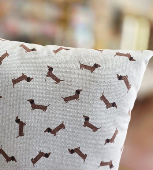 cojín infantil con estampado de perros salchicha.