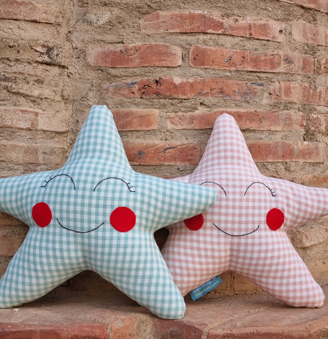 Cojines con forma de estrella de cuadros vichy, rosa palo y verde mar. Cojines estrella que son el perfecto para decorar la cuna o la cama infantil.